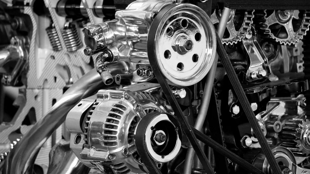 greyscale-photography-of-car-engine-190574 Close-up of a shiny car engine showing polished metal parts and gears in black and white.